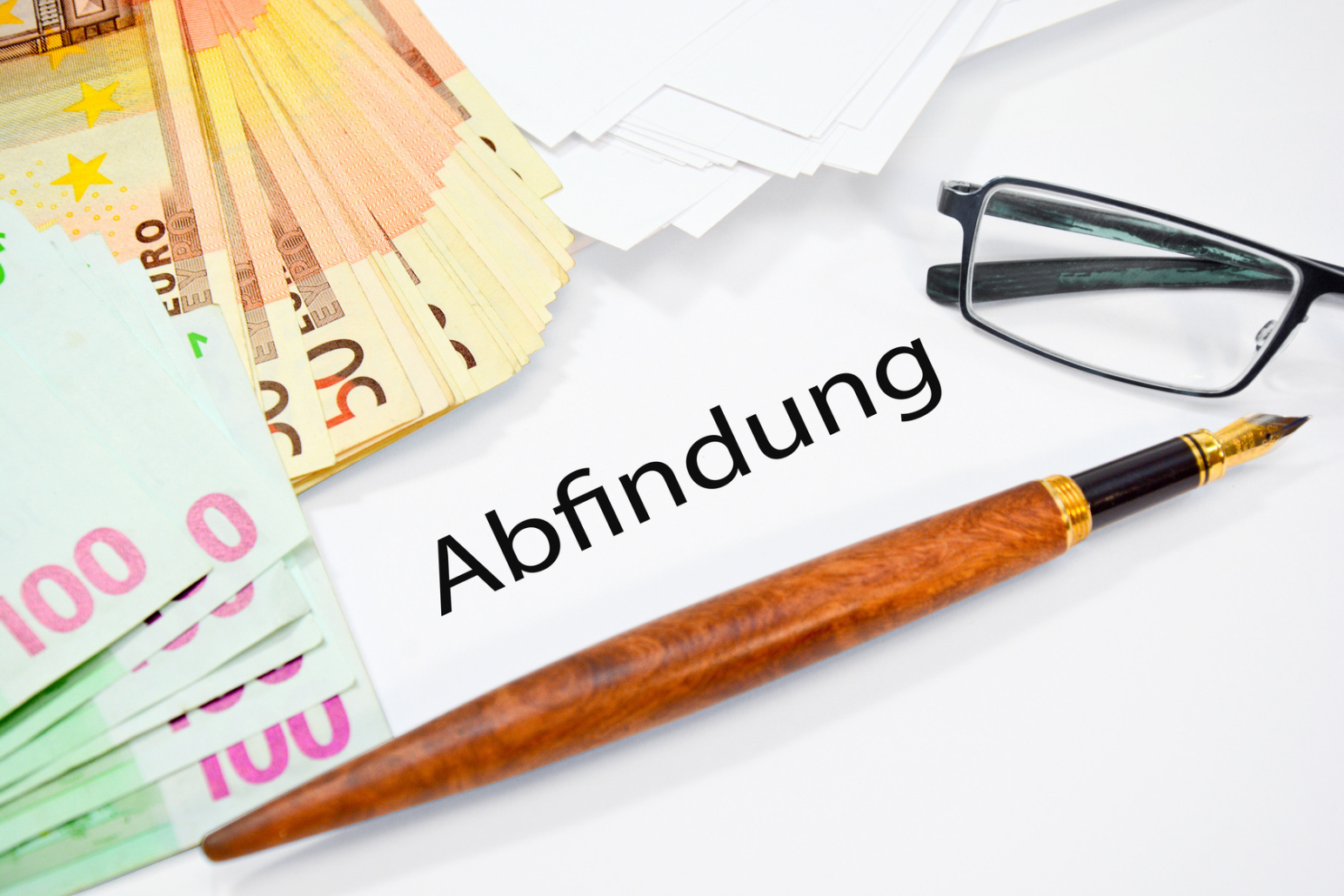 "Abfindung" in Druckschrift, ein Stift, eine Brille und diverse Geldscheine; Privatdetektiv Bochum, Privatdetektei Bochum, Privatermittler Bochum, Unterhaltsermittlungen