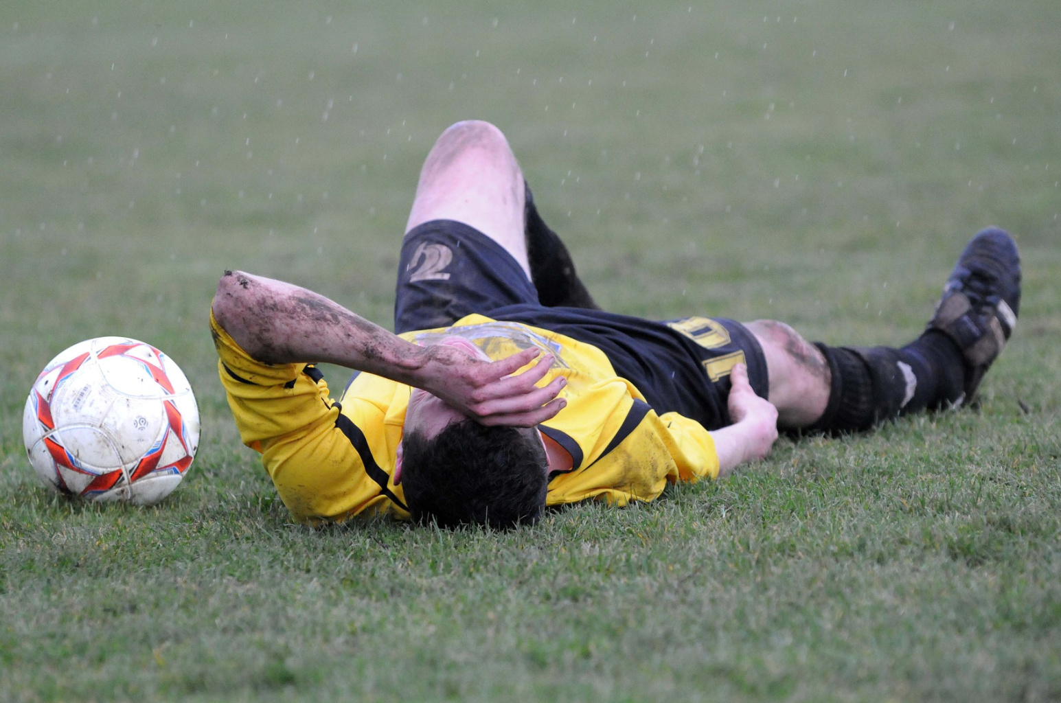 Ein Fußballspieler liegt mit Schmerzen auf dem Rasen; Detektiv Bochum | Kurtz Detektei Bochum, Mitarbeiterüberprüfung Bochum