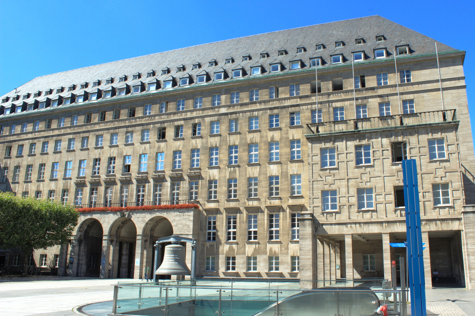 Bochumer Rathaus an einem sonnigen Tag, davor Glocke der Weltausstellung 1867 in Paris; Kurtz Privatdetektei Bochum